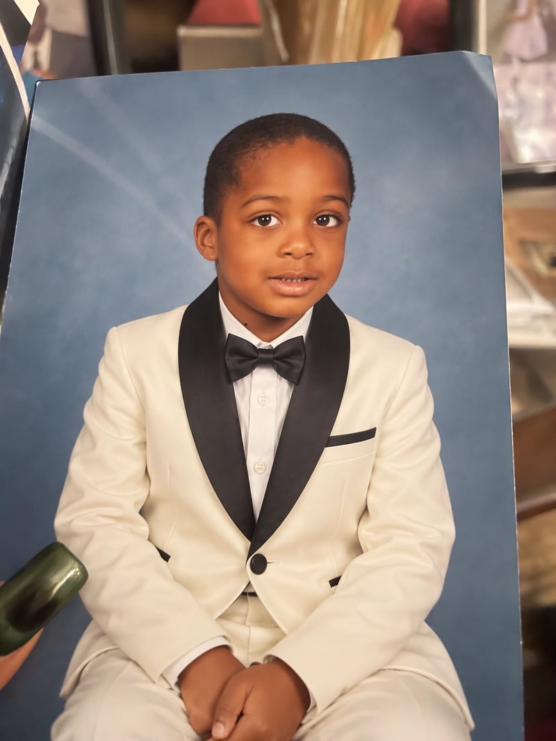 The same printed portrait with the child in an ivory tuxedo, black lapels, and a black bow tie